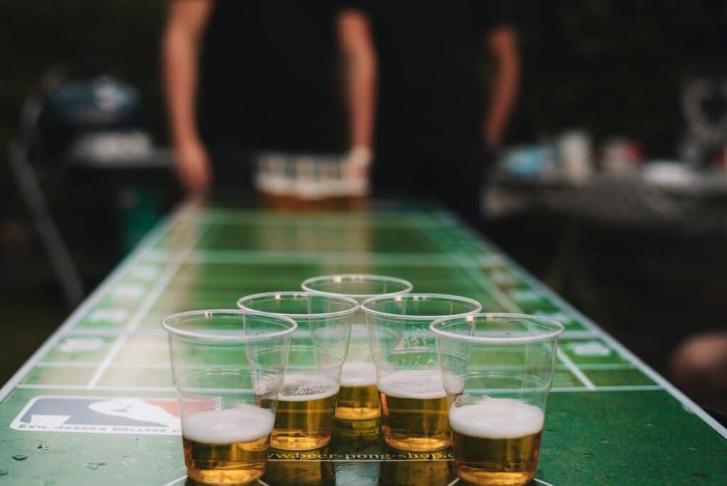 Closeup shot of cups of beer on a beer pong table